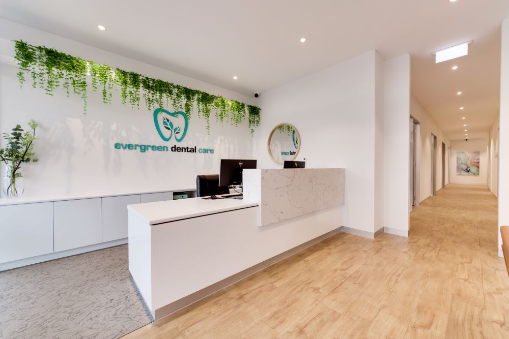 Evergreen Dental Care’s reception area is inviting and natural with a touch of greenery. It’s multi-tiered desk is designed for ease of communication with patients.